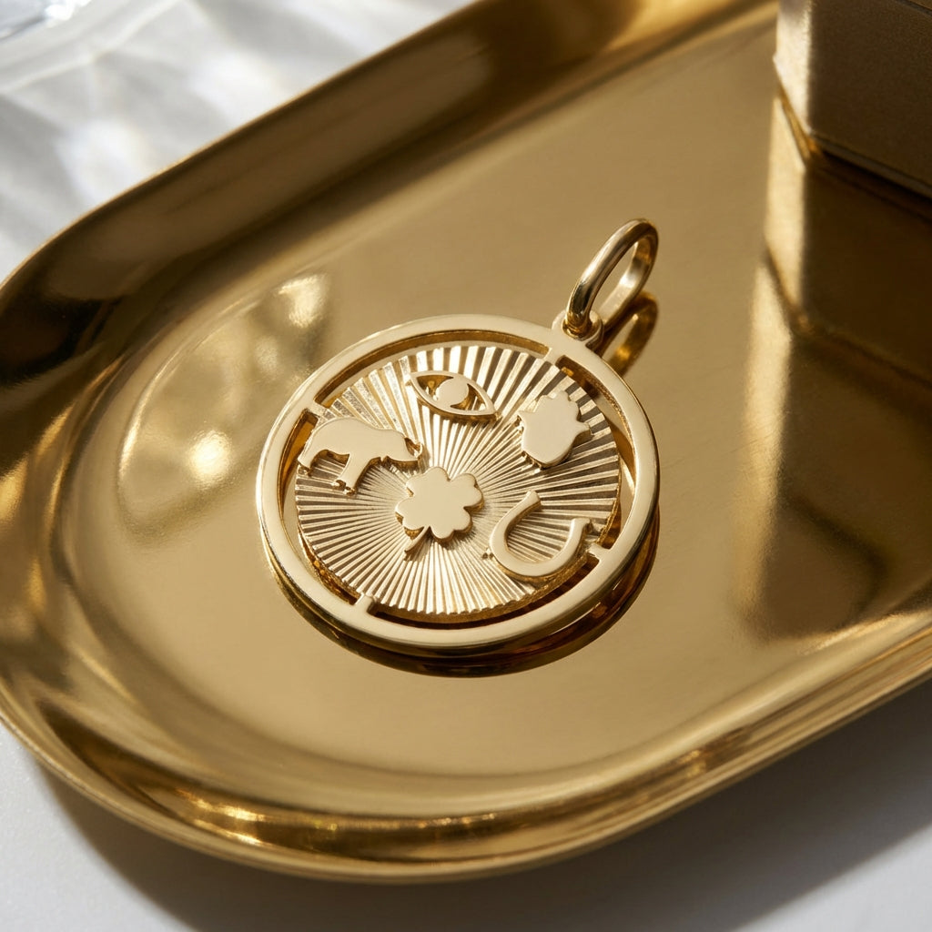 Small 14K gold Hamsa evil eye pendant on a reflective surface, showcasing intricate texture and radiant sunburst pattern.